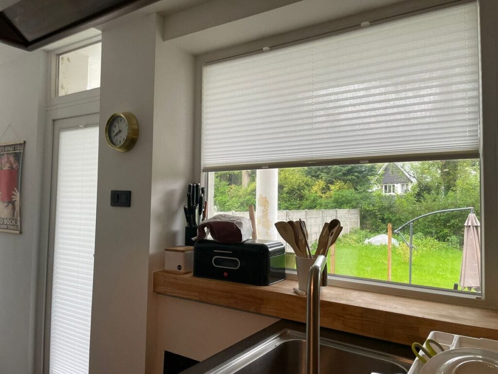 cortina plisada entre junquillos de ventana